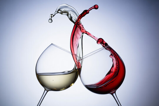 Red and white wine splashing in glasses isolated on white background