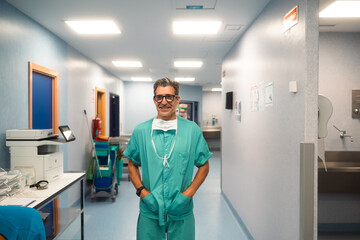 Smiling surgeon in hospital hallway
