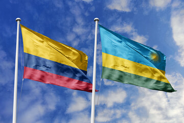 Waving flags of Colombia and Rwanda against a vibrant blue sky, symbolizing international relations...