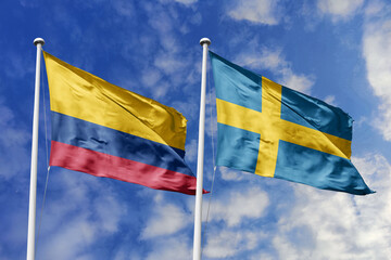 Waving flags of Colombia and Sweden against a vibrant blue sky, symbolizing international relations...
