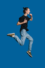 A Vibrant and Energetic Young Man is Joyfully Running While Enjoying a Delicious Snack on the Go