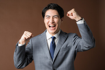 Top half of a gutsy businessman in a suit on a brown background Image of a professional or real...