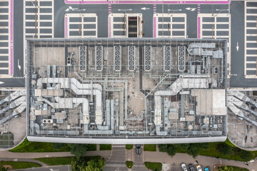 Top-down symmetrical view of rooftop air conditioning ducts and fans arranged in organized grid...