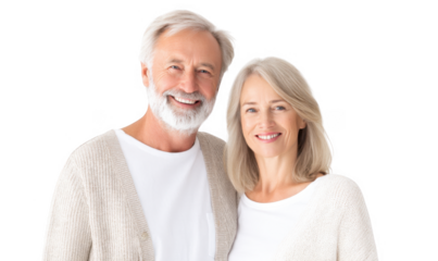 A joyful elderly couple smiling warmly at the camera. dressed in cozy sweaters. standing against a bright white background. conveying happiness and love in a serene home setting