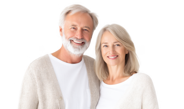 A joyful elderly couple smiling warmly at the camera. dressed in cozy sweaters. standing against a bright white background. conveying happiness and love in a serene home setting