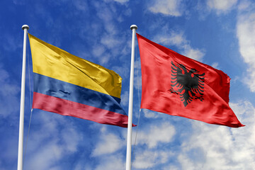 The Striking Flags of Colombia and Albania Waving Boldly Together Under a Bright Blue Sky, Representing Diplomatic Ties and a Harmonious International Relationship.