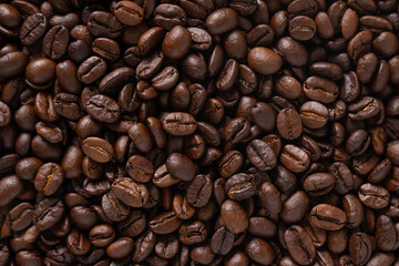 Roasted coffee beans background. Top view of dark brown coffee beans. Close up image.