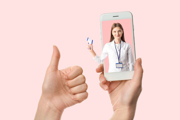 Female hands with mobile phone showing thumb-up gesture on white background