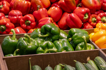 Vibrant assortment of fresh bell peppers in red, orange, and yellow hues organized attractively....