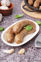 Plate of tasty homemade sausages on grunge background
