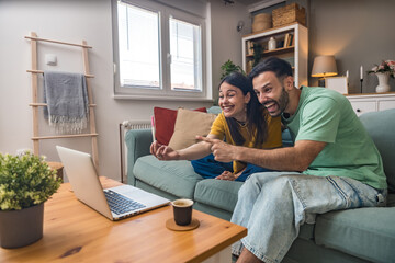 Surprised happy couple announcing their pregnancy to family and friends during a video call. Young...