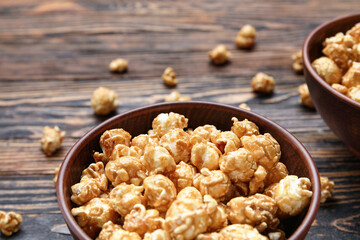 Bowls with tasty popcorn on wooden background
