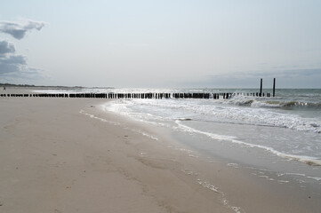 A Beautiful Tranquil Beach Scene Featuring Gentle Waves Rolling In and Piers Extending Out