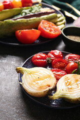 Plate with tasty grilled vegetables on dark background