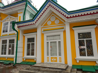 Yellow wooden building with white frames in central Almaty