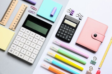 Modern calculators with different stationery on color background