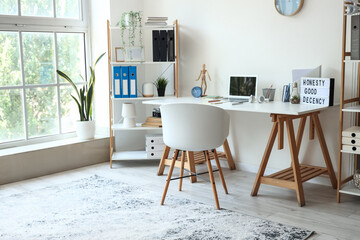 Interior of light office with modern workplace and shelving units