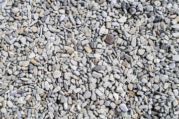 Top view of small round beach pebbles in natural tones creating a textured surface. Concept of...