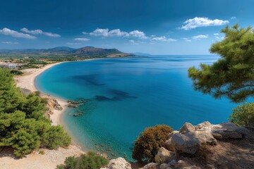 Obraz premium Coastal scene with clear blue water beach vegetation rocks and mountains in the background under a partly cloudy sky