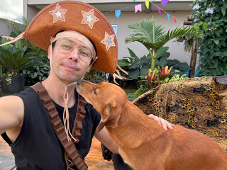 homem com fantasia de lampião para festa junina com cachorro caramelo doméstico 