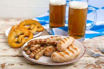 Plate with tasty Bavarian sausages on white wooden background. Oktoberfest celebration
