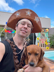 homem com fantasia de lampião para festa junina com cachorro caramelo doméstico 