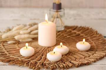 Burning candles on white wooden background