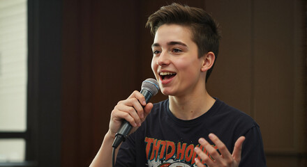 Teen boy speaking into a microphone with enthusiasm indoors  
