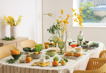 Autumn table setting with flowers, leaves and pumpkins