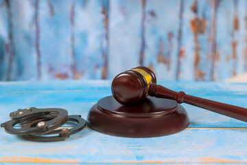 Justice gavel prominently placed on wooden surface beside handcuffs serious atmosphere conveys...