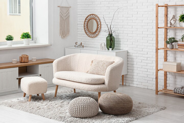 Interior of modern living room with dresser, sofa and poufs
