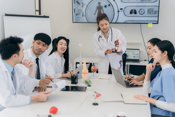 Doctors are talking casually on laptops to prepare for treatment and are having a meeting in the office. The medical team is talking and working together in the hospital.
