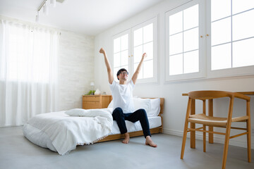 部屋で伸びをする男性