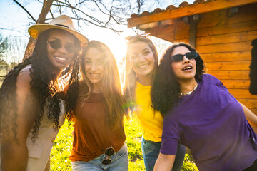 Four young women embracing friendship in golden sunlight