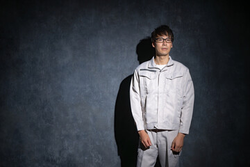 暗い背景の中で作業服を着た男性