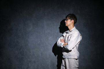 腕組みをする作業服姿の男性
