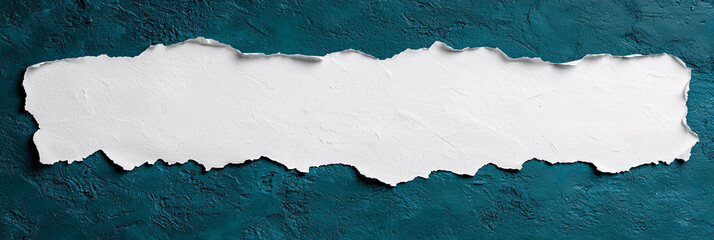 A ripped sheet of paper reveals rough texture on dark turquoise painted surface background.