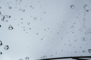 Raindrops and bubbles scatter across a wet surface, capturing nature’s freshness and moisture in...