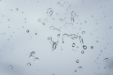 Raindrops and bubbles scatter across a wet surface, capturing nature’s freshness and moisture in...