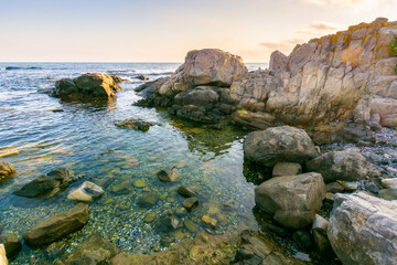 beautiful sunrise at the black sea. outdoor adventure. rocky coast and clouds on the blue sky in...