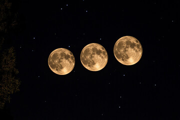 Naklejka premium Three full moons shining brightly in a starry night sky
