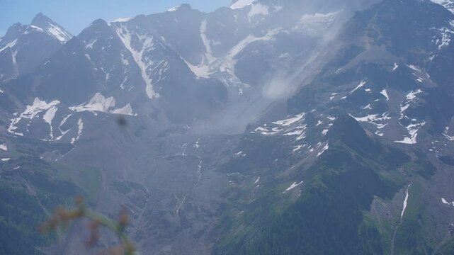 Scenic view of rockfall with dust, gravel, snow and glacier at mountain peaks Kleines Nesthorn and Bietschhorn on a sunny late spring day. Movie shot June 19th, 2025, L&ouml;tschental, Switzerland.