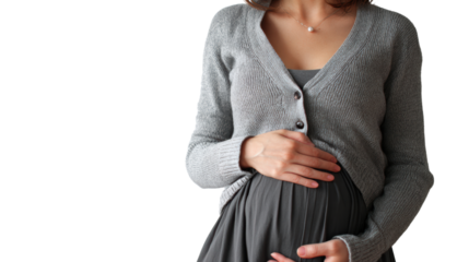Pregnant woman in a cozy cardigan gently cradles her baby bump with a serene expression.