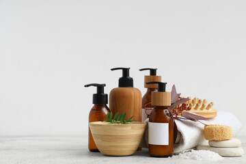 Set of cosmetic products, spa accessories and plants on light background