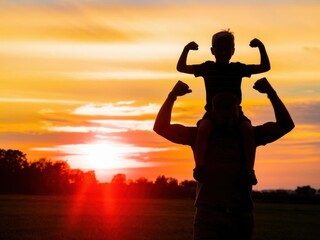 A Father and Son Silhouette Bonding at Sunset with Arm Muscle Gesture