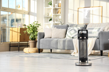 Electric heater on floor in light living room interior