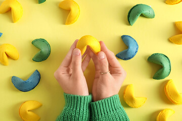 Female hands with different fortune cookies on yellow background