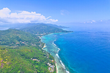 Drone shot of south east coast of, turquoise water, lush mountain and white sandy beaches, Mahe, Seychelles 2