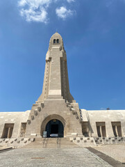 View of the Douaumont Ossuary from the military cemetery in Verdun, France, under a clear sky, commemorating World War I soldiers