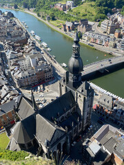 Aerial view of Dinant, Belgium, from the top of the citadel on a clear day, overlooking the Meuse River, cityscape, and surrounding landscape.